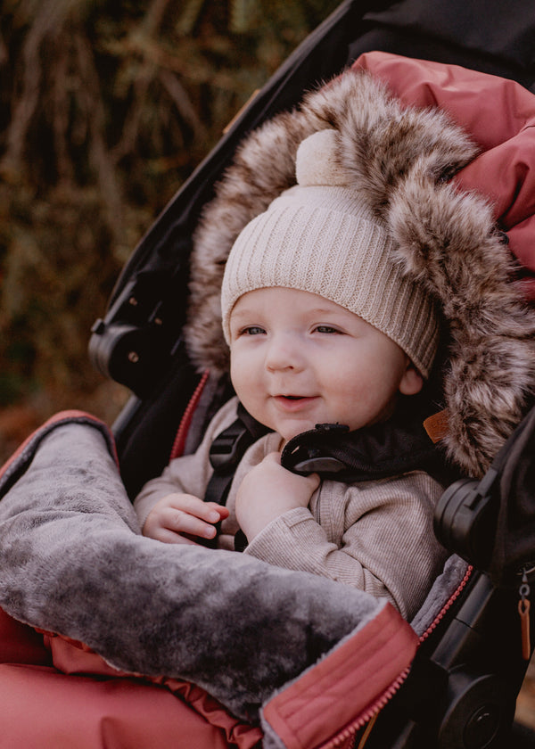 Baby in a stroller with a baby luno footmuff with a fur-lined hood