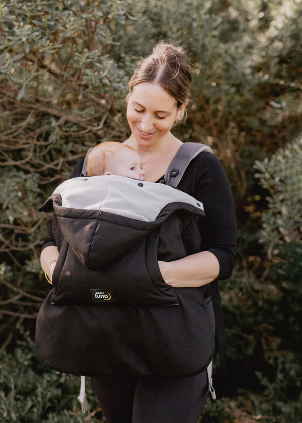 Mother carrying a baby in a baby carrier with the baby luno Carrier Cocoon Winter Cover.