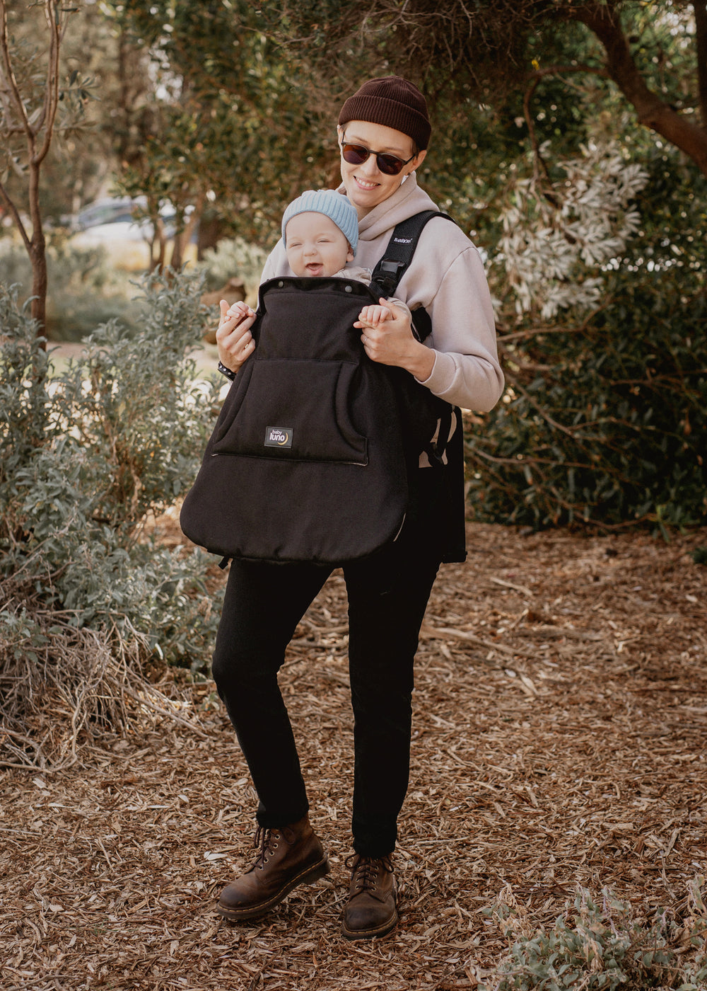 Mother carrying a baby in a baby carrier with the baby luno Carrier Cocoon Winter Cover.