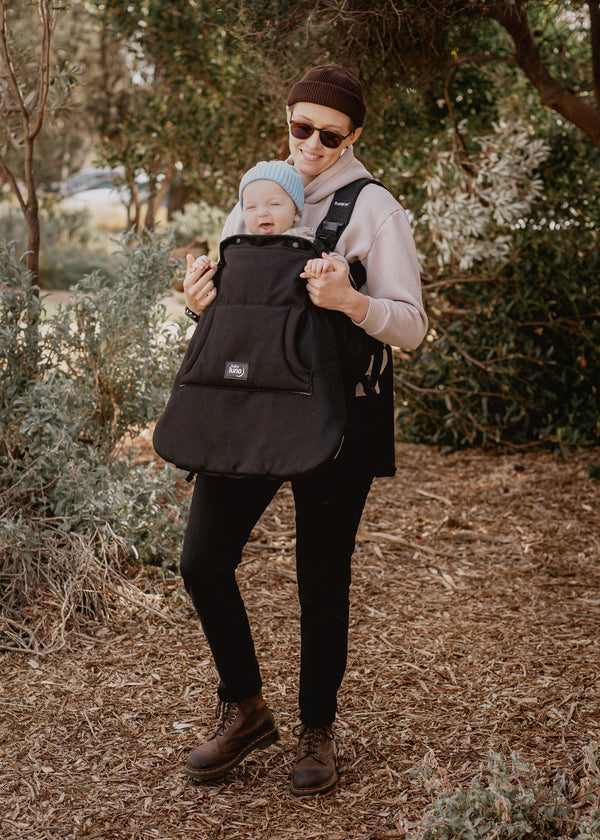 Parent holding a baby in a baby carrier with the baby luno Carrier Cocoon Winter Cover