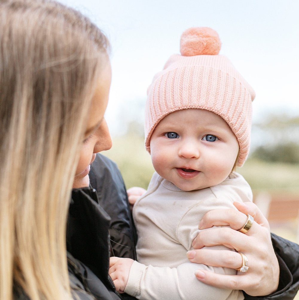 Pink knit beanie with a pom-pom